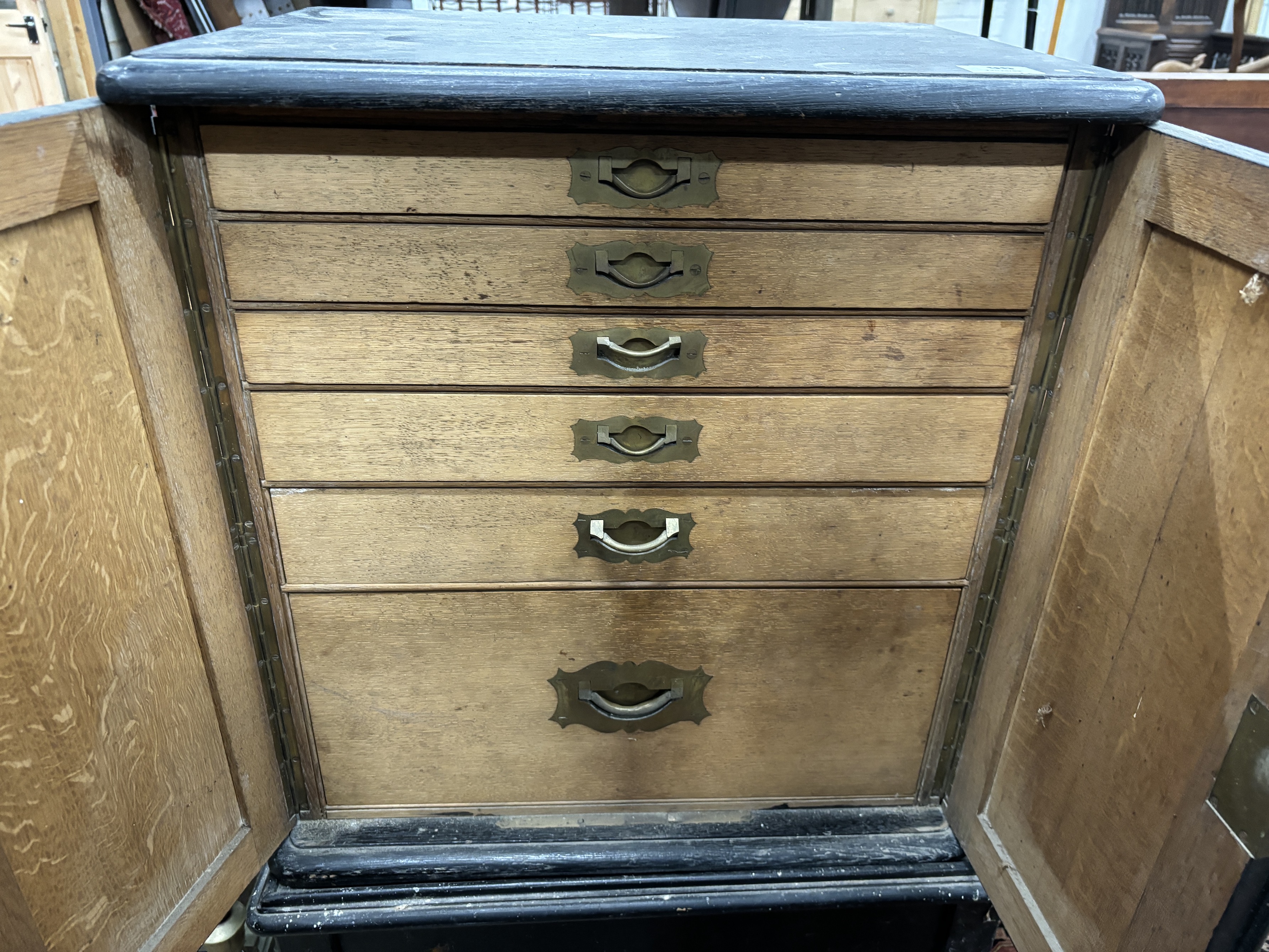 An Edwardian ebonised oak canteen cabinet on associated stand, width 64cm, depth 49cm, height 113cm